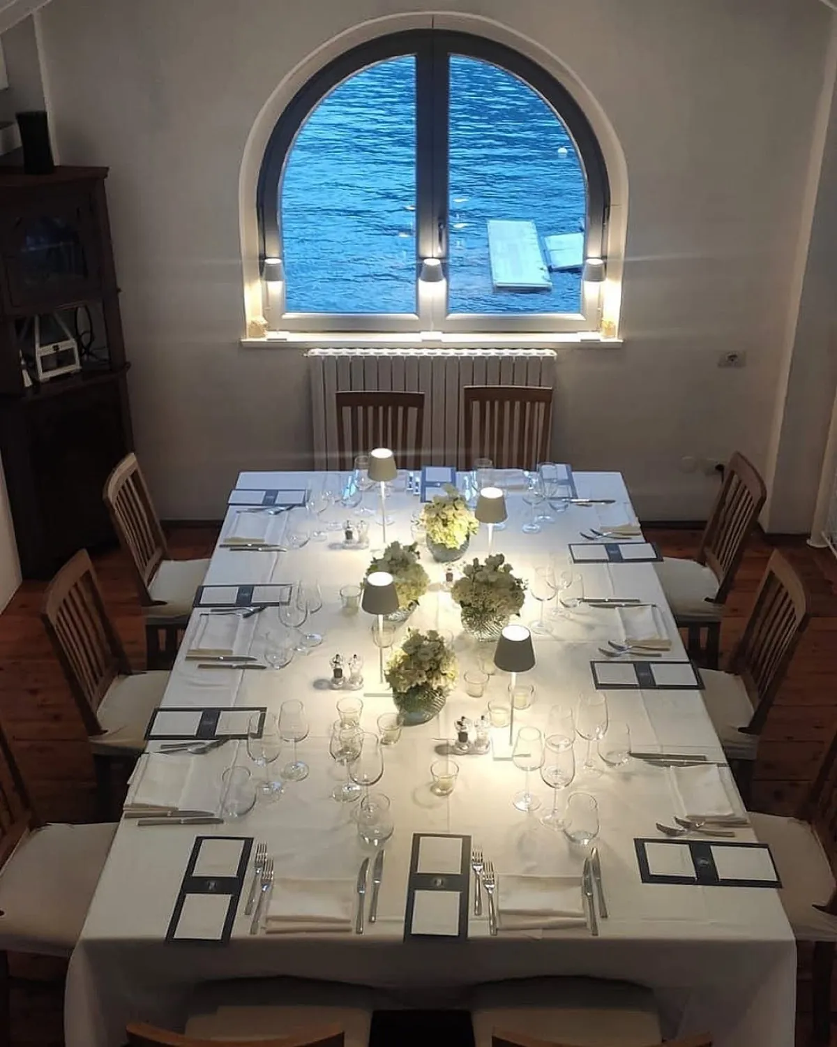 Sala interna allestita per un evento con grande finestra sul lago